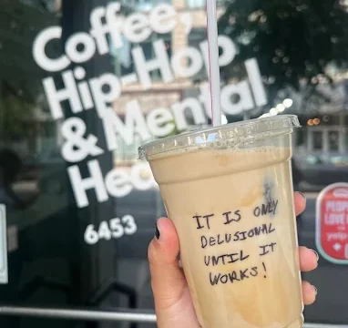 Coffee cup being held in front of exterior of CHHMH