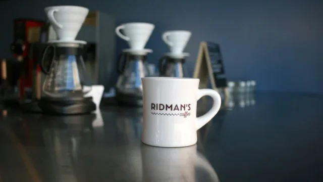 Ridman's Coffee imprinted mug in front of brewers